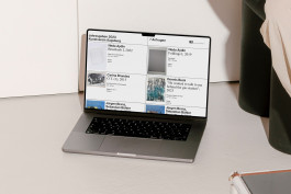 Photography of a MacBook standing on the floor showing the website of the Jahresgaben 2023. 